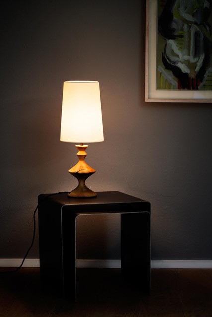Eine Leuchte steht auf einem Tisch und erzeugt ein warmes Licht